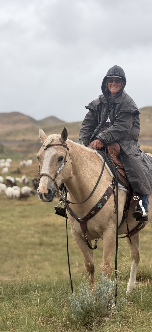 Jody Spellman wearing a raincoat while sitting on horseback
